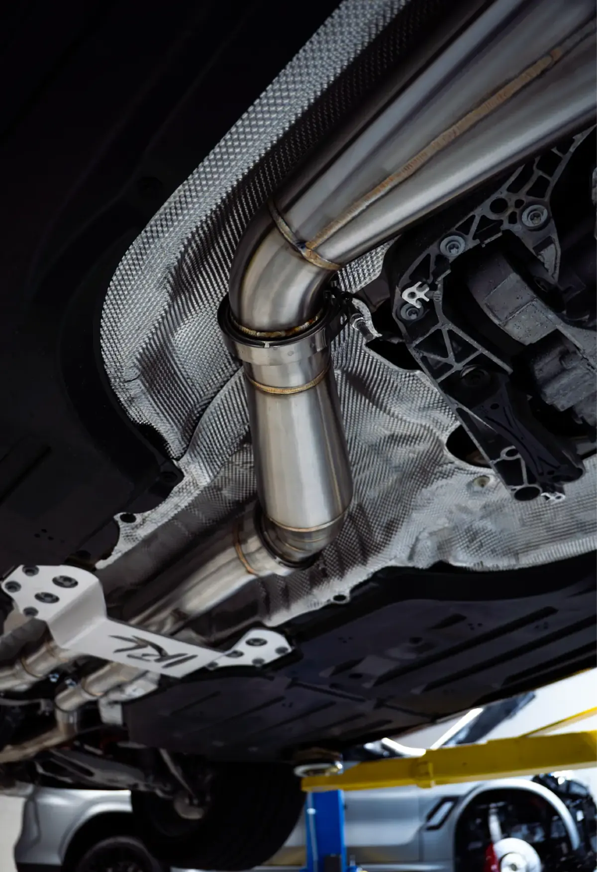 Stainless VRSF downpipe seen from underneath a car on a lift