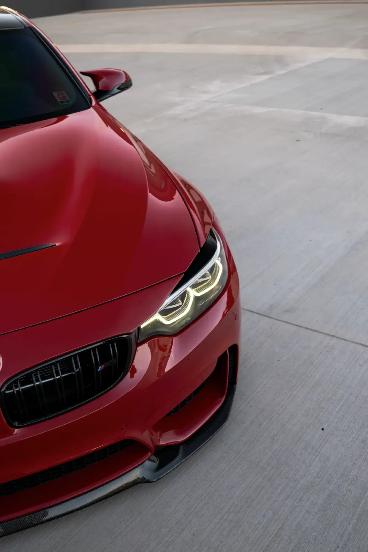 Close-up of a red F8x M3/M4 front bumper, grille and headlight