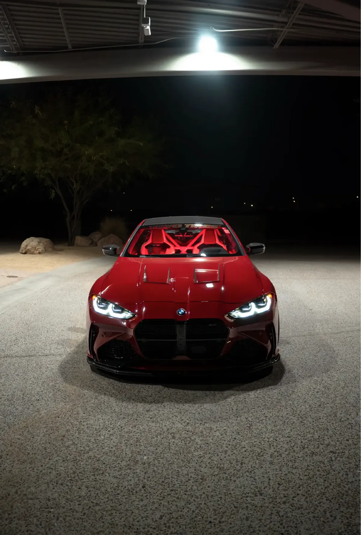 Front view of a maroon G82 M4 at night with its headlights on