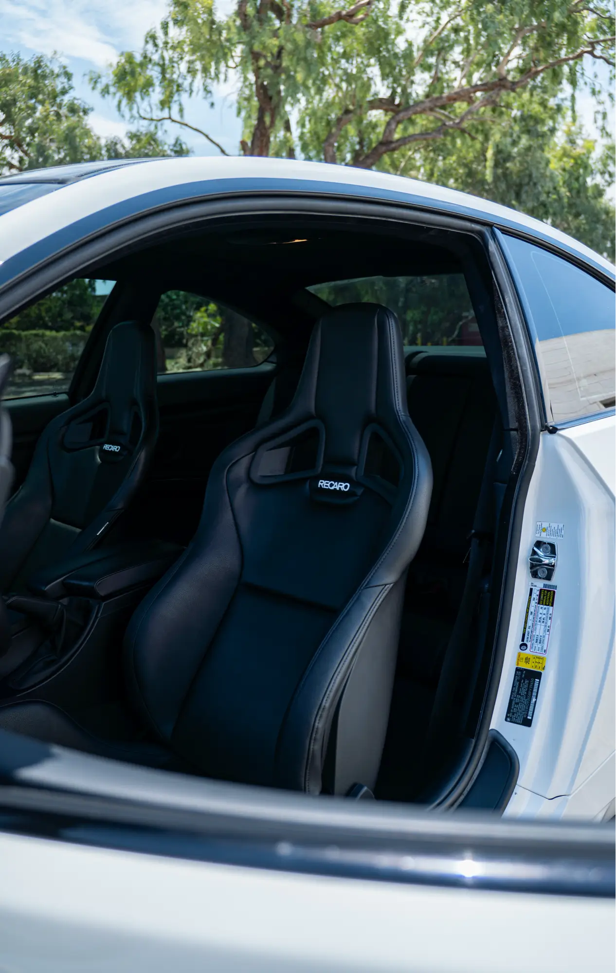 Interior of a white BMW E92 M3 showing its Recaro bucket seats.