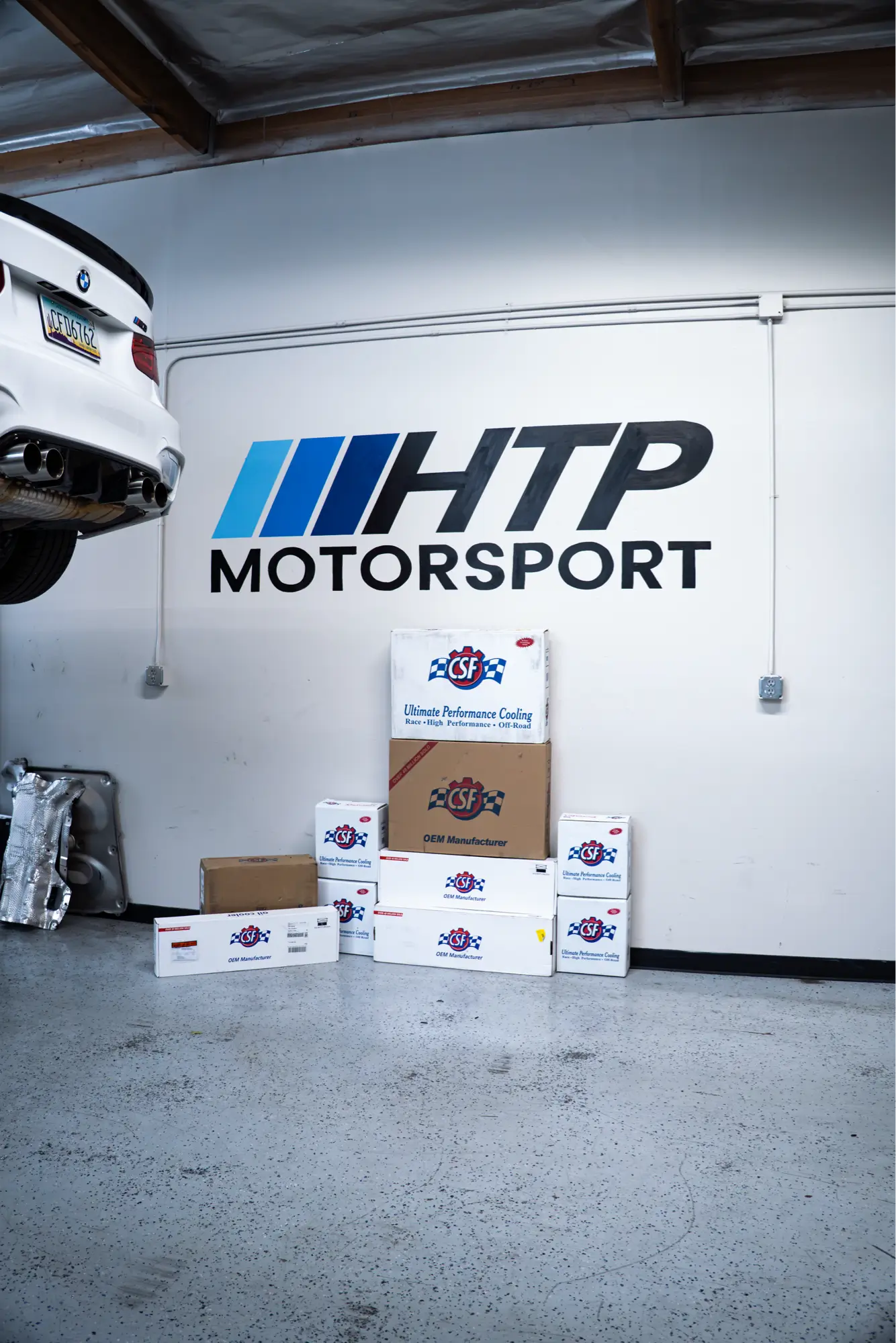 CSF cooling parts boxes stacked along a shop wall at HTP Motorsport.