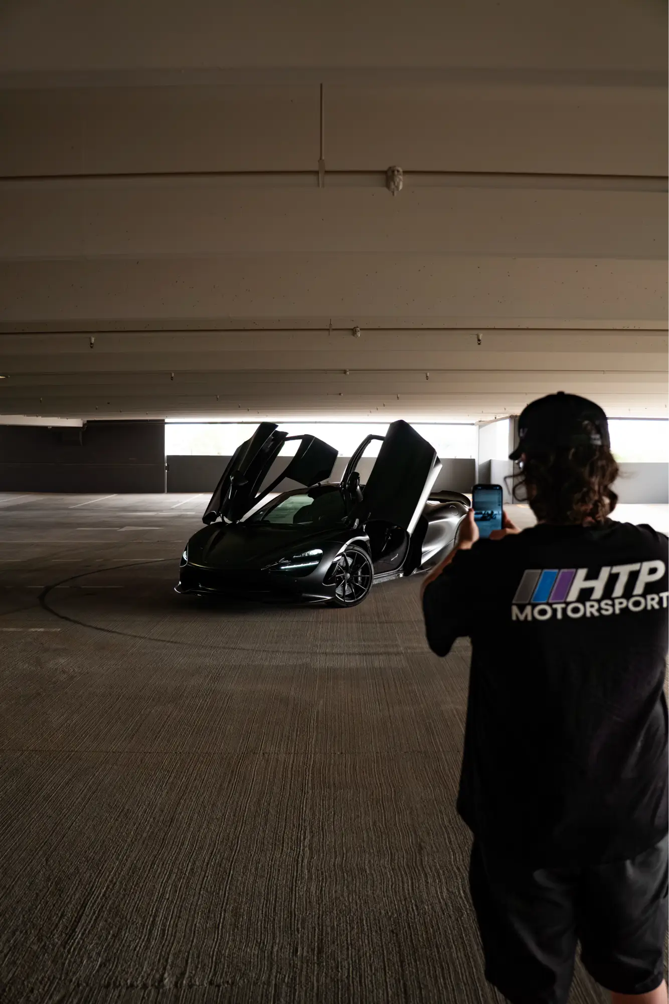 Orange McLaren 720S shown front three-quarter in a dimly lit parking garage.